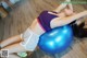 A woman laying on an exercise ball on the floor.