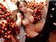 A naked woman sitting in front of a bunch of fruit.