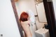 A naked woman standing in a bathroom next to a sink.