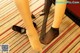 A woman wearing black stockings and high heels standing on a carpeted floor.