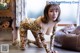 A woman in a leopard print catsuit posing on the floor.