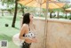 A woman in a polka dot bikini standing under an umbrella.