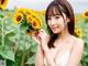 A woman holding a bunch of sunflowers in a field.