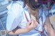 A woman in a white shirt is holding a cell phone.
