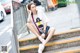 A woman sitting on the steps of a city street.