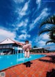 A woman jumping into a swimming pool with an inflatable ring.